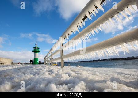 Gefrorenes Meerwasser ist an der Mole vom Leuchtturm Travemünde in Lübeck-Travemünde zu sehen. Stockfoto