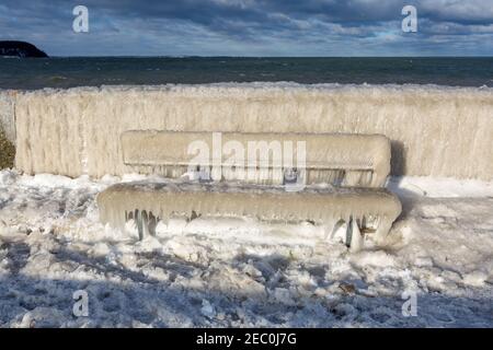 Gefrorenes Meerwasser ist an der Mole vom Leuchtturm Travemünde in Lübeck-Travemünde zu sehen. Stockfoto