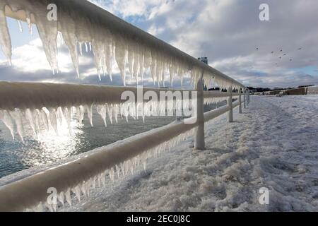 Gefrorenes Meerwasser ist an der Mole vom Leuchtturm Travemünde in Lübeck-Travemünde zu sehen. Stockfoto