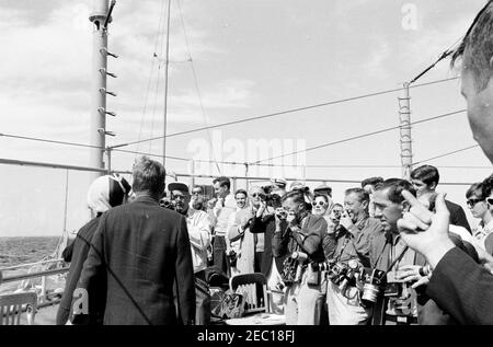 Präsident Kennedy beobachtet das 1st Americau0027s Cup Race. Präsident John F. Kennedy und First Lady Jacqueline Kennedy (beide links) nehmen am ersten Rennen des Cup 1962 Americau0027s an Bord der USS Joseph P. Kennedy, Jr. Teil. Ebenfalls im Bild: Stellvertretender Finanzminister James A. Reed; Senator Edmund S. Muskie (Maine); Anita Marcus Fay (Ehefrau des Untersekretärs der Marine, Paul u0022Redu0022 Fay); Hugh D. Auchincloss; Janet Lee Auchincloss; Fotograf des Weißen Hauses, Chief Robert L. Knudsen; John Forbes Kerry; Janet Jennings Auchincloss. Unbekannte Fotografen beobachten. Newport, Rhode Stockfoto