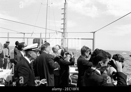 Präsident Kennedy beobachtet das 1st Americau0027s Cup Race. Präsident John F. Kennedy und First Lady Jacqueline Kennedy (beide schauen durch ein Fernglas) beobachten das erste Rennen des Cup 1962 Americau0027s von Bord der USS Joseph P. Kennedy, Jr. auch im Bild: Chef des Protokolls, Angier Biddle Duke; Julia Ann Shepard (Ehefrau von Naval Aide to the President, Captain Tazewell Shepard); Skipper der Präsidentenyacht, u201cManitou,u201d Leutnant Charles Reid; Franklin D. Roosevelt, Jr.; Hugh D. Auchincloss; Jamie Auchincloss; Janet Jennings Auchincloss. Newport, Rhode Island. Stockfoto