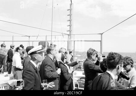 Präsident Kennedy beobachtet das 1st Americau0027s Cup Race. Präsident John F. Kennedy (rechts, Blick durch das Fernglas) und First Lady Jacqueline Kennedy (Mitte) beobachten das erste Rennen des Cup 1962 Americau0027s von Bord der USS Joseph P. Kennedy, Jr. auch im Bild: Stellvertretender Finanzminister, James A. Reed; Chef des Protokolls, Angier Biddle Duke; Botschafter von Großbritannien, Sir David Ormsby-Gore; Julia Ann Shepard (Frau des Naval Aide an den Präsidenten, Kapitän Tazewell Shepard); Skipper der Präsidentenyacht, u201cManitou,u201d Leutnant Charles Reid; Franklin D. Rooseve Stockfoto