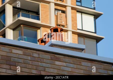 Detail von 3 alten Stil Terrakotta-farbigen Lüftungshauben auf Vorstadt Dach Stockfoto