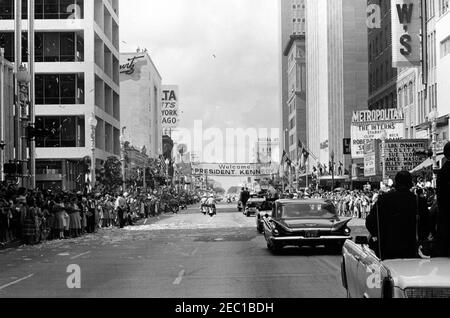 Besichtigung der NASA-Installationen: Houston, Texas, Autokolonne, Adresse an der Rice University, 9:34am Uhr. Präsident John F. Kennedy (Mitte rechts, im Hintergrund) steht in der Präsidentenlimousine (Lincoln-Mercury Continental Cabrio), während seine Autokolonne die Main Street in Houston, Texas, auf dem Weg zur Rice University entlang fährt. Konfetti fällt auf die Autokolonne, Menschenmassen säumen die Straße. Stockfoto