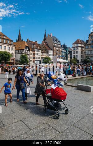 Straßburg, Frankreich - 29. Juli 2017: Failies, Einheimische und Besucher Menschen Fußgänger, die an einem warmen Sommertag auf dem zentralen Platz Kleber mit der Kathedrale Notre-Dame im Hintergrund spazieren gehen Stockfoto