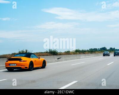 Baden-Baden, Deutschland - 7. Juli 2019: Rasante Fahrt auf der deutschen Autobahn eines orangefarbenen Porsche 911 Sportwagens Stockfoto