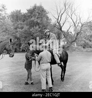 First Lady Jacqueline Kennedy (JBK) fährt mit Muhammad Ayub Khan, Präsident von Pakistan in Glen Ora, Middleburg, Virginia. Der Präsident Pakistans, Muhammad Ayub Khan, sitzt mit einem Pferd auf dem Gelände von Glen Ora in Middleburg, Virginia. First Lady Jacqueline Kennedyu2019s Pferd, u201cSardar,u201d vorgestellt Frau Kennedy als Geschenk von Präsident Ayub Khan während ihrer Reise nach Pakistan, steht ganz links. Stockfoto