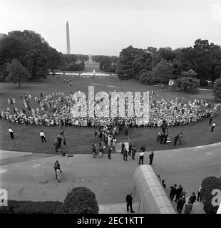 Besuch der Teilnehmer der Wahlkampfkonferenz für Demokratische Frauen 1962, 9:35am Uhr. Besuch der Teilnehmer der Wahlkampfkonferenz für demokratische Frauen 1962; Präsident John F. Kennedy und First Lady Jacqueline Kennedy stehen auf der Plattform (Mitte). Ebenfalls im Bild: Stellvertretende Vorsitzende des Demokratischen Nationalkomitees (DNC), Margaret B. Price; Vizepräsident Lyndon B. Johnson; Senator Hubert H. Humphrey (Minnesota); Senator Mike Mansfield (Montana); Senator George Smathers (Florida); Repräsentant Hale Boggs (Louisiana); Repräsentant Carl Albert (Oklahoma); Pressesprecher Pierre Salinger; Spe Stockfoto