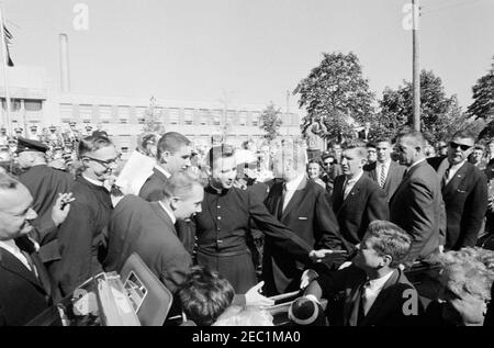 Kongreßfeldzug Reise: Cleveland, Ohio, Ankunft, Rallye, Autokolonne, Abfahrt. Präsident John F. Kennedyu2019s hält während einer Wahlkampfreise vor der St. Edward High School in Lakewood, Ohio; Präsident Kennedy besucht Studenten und Priester der Schule, nachdem er im Namen des Studentenkörpers des Präsidenten der höheren Klasse, Robert Cutter, und des Prinzipals, Bruder Charles Krupp, einen Fußball erhalten hatte. Ebenfalls im Bild: Senator Frank Lausche aus Ohio (im Rücksitz des Cabrios mit Präsident Kennedy); Bruder Florentius Schu (links stehend); Vorsitzender des Cuyahoga C. Stockfoto