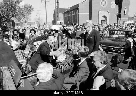 Kongreßfeldzug Reise: Cleveland, Ohio, Ankunft, Rallye, Autokolonne, Abfahrt. Präsident John F. Kennedyu2019s Autokolonne hält auf einer Straße in Cleveland, Ohio, während einer Kongresskampagne Reise. Präsident Kennedy sitzt auf dem Rücksitz des Cabrios mit Senator Frank Lausche (Ohio) und Gouverneur von Ohio, Michael V. DiSalle; Vertreter Michael J. Feighan (Ohio) sitzt auf dem Vordersitz (zurück zur Kamera). Menschenmassen säumen die Straße. Stockfoto