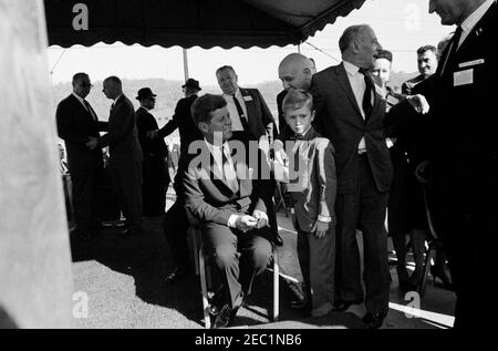 Wahlkampfreise im Kongress: McKeesport, Pennsylvania, Kundgebung. Präsident John F. Kennedy besucht mit einem kleinen Jungen während einer Wahlkampfveranstaltung im Kongress auf dem städtischen Parkplatz am Rathaus in McKeesport, Pennsylvania. Der Geheimagent des Weißen Hauses, Floyd Boring, steht ganz links im Hintergrund. Stockfoto