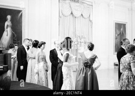 Abendessen zu Ehren von Vizepräsident Lyndon B. Johnson (LBJ), Sprecher des Hauses John W. McCormack, u0026 Chief Justice Earl Warren, 8:00pm Uhr. Die Mezzosopran-Opernsängerin Grace Bumbry (Mitte, im Profil) steht mit Gästen im East Room nach ihrem Auftritt bei einem Dinner zu Ehren von Vizepräsident Johnson, dem Sprecher des Repräsentantenhauses John W. McCormack und dem Obersten Gerichtshof Earl Warren. Direktor des Bundesuntersuchungsamtes J. Edgar Hoover (Dritter von rechts, teilweise versteckt) steht mit anderen Gästen in der Empfangsleitung. White House, Washington, D.C. Stockfoto