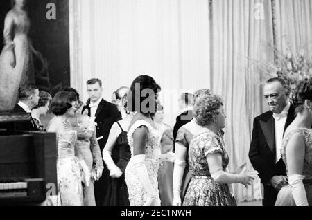 Abendessen zu Ehren von Vizepräsident Lyndon B. Johnson (LBJ), Sprecher des Hauses John W. McCormack, u0026 Chief Justice Earl Warren, 8:00pm Uhr. Die Mezzosopran-Opernsängerin Grace Bumbry (Mitte, im Profil) steht mit Gästen im East Room nach ihrem Auftritt bei einem Dinner zu Ehren von Vizepräsident Johnson, dem Sprecher des Repräsentantenhauses John W. McCormack und dem Obersten Gerichtshof Earl Warren. Der Direktor des Federal Bureau of Investigation J. Edgar Hoover (zweiter von rechts) steht mit anderen Gästen in der Empfangsleitung. White House, Washington, D.C. Stockfoto