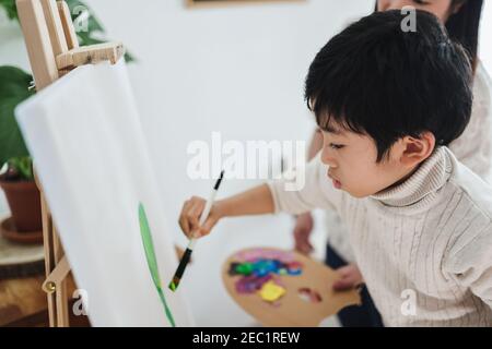 Asiatische Kinder Malerei auf Leinwand während der Kunstunterricht zu Hause - Fokus auf Kinderauge Stockfoto