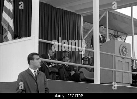 Dedication Ceremonies, Dulles International Airport, 11:12am Uhr. Der Administrator der Federal Aviation Agency (FAA), Najeeb Halaby (am Rednerpult), hält bei der Einweihungszeremonie für den internationalen Flughafen Dulles, benannt nach dem verstorbenen Außenminister John Foster Dulles, Bemerkungen; Präsident John F. Kennedy (schriftlich) sitzt in der Mitte links. Ebenfalls auf der Plattform von speakersu0027 abgebildet: Vertreter Oren Harris (Arkansas); Militärhilfe an den Präsidenten, General Chester V. Clifton (stehend); Stabschef der United States Air Force, General Curtis E. LeMay. Geheimagent des Weißen Hauses, Ken Stockfoto