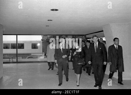 Dedication Ceremonies, Dulles International Airport, 11:12am Uhr. Präsident John F. Kennedy (Mitte, Holding hat) führt durch das Terminalgebäude des Dulles International Airport bei Einweihungszeremonien für den Flughafen, der nach dem verstorbenen Staatssekretär John Foster Dulles benannt wurde; Aline B. Saarinen (Witwe des Architekten für den Flughafen, Eero Saarinen) und Administrator der Federal Aviation Agency (FAA), Najeeb Halaby, gehen Sie rechts von Präsident Kennedy. Auch abgebildet: Gouverneur von Virginia, Albertis S. Harrison, Jr.; ehemaliger Administrator der FAA, General Elwood R. u201cPeteu201d Quesada; Deputy Ad Stockfoto