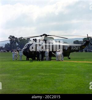 Festrede an der United States Military Academy, West Point (New York), 10:01AM Uhr. Präsident John F. Kennedy tritt bei seiner Ankunft an der United States Military Academy (USMA), West Point, New York, aus einem Hubschrauber der United States Army für Abschlussübungen. Militärhilfe für den Präsidenten, General Chester V. Clifton, geht hinter Präsident Kennedy; Geheimagent des Weißen Hauses, Arthur L. u201cArtu201d Godfrey, steht links vom Hubschrauber. The Plain, USMA, West Point, New York. Stockfoto