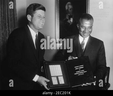 Treffen mit Sylvanus Olympio, Präsident von Togo, 2:53pm Uhr. Präsident von Togo, Sylvanus Olympio (rechts), überreicht Präsident John F. Kennedy einen Satz togolesischer Briefmarken zu Ehren der Astronauten John H. Glenn, Jr. und Alan B. Shepard, Jr. Kabinettsaal, Weisses Haus, Washington, D.C.. [Farbdurchblutung in der oberen rechten Ecke ist original zum Aktenabdruck.] [Siehe auch MO 63,3248, u201cStamps zu Ehren der Astronauten Glenn und Shepardu201d] Stockfoto