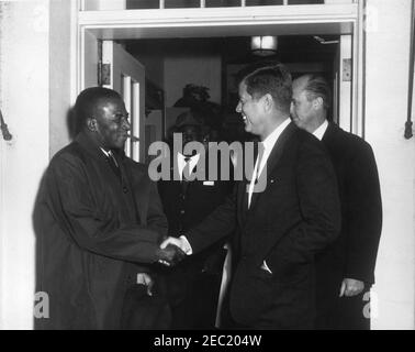 Treffen mit Sylvanus Olympio, Präsident von Togo, 2:53pm Uhr. Präsident John F. Kennedy schüttelt die Hände mit Präsident von Togo, Sylvanus Olympio (links), nach Präsident Olympiou2019s Abreise aus dem Weißen Haus nach einem Treffen und Mittagessen. DER US-Chef des Protokolls, Angier Biddle Duke, steht direkt hinter Präsident Kennedy. Eingang im Westflügel, weißes Haus, Washington, D.C. Stockfoto