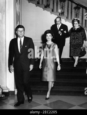 Diplomatischer Empfang, 6:30pm Uhr. Präsident John F. Kennedy und First Lady Jacqueline Kennedy kommen in der Eingangshalle für einen diplomatischen Empfang im Weißen Haus an. Der Botschafter Nicaraguas und Dekan des Diplomatischen Korps, Dr. Guillermo Sevilla-Sacasa, und Lillian Somoza de Sevilla-Sacasa steigen die große Treppe hinab. White House, Washington, D.C. Stockfoto