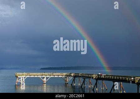 Sidney, British Columbia am Wasser. Ein Regenbogen über dem Fishing Pier im Frühjahr. Stockfoto