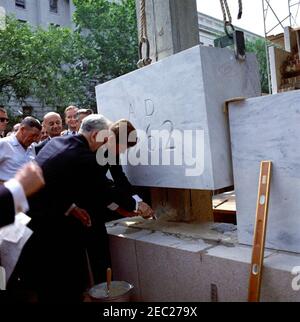 Grundsteinlegung, Bürogebäude Rayburn House, 10:28am Uhr. Präsident John F. Kennedy und der Sprecher des Repräsentantenhauses und Vorsitzender der House Office Building Commission, John W. McCormack (Massachusetts), nehmen an der Grundsteinlegung für das Rayburn House Office Building Teil, die dem verstorbenen Sprecher des Hauses, Sam Rayburn, gewidmet ist. Zu den anderen gehören: Repräsentant Charles MCC. Mathias, Jr. (Maryland); Vertreter Roman C. Pucinski aus Illinois (Gesicht verdeckt); Geheimagent des Weißen Hauses, Milt Wilhite. Washington, D.C. Stockfoto