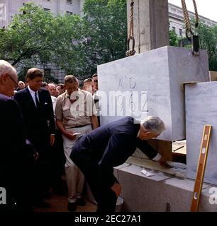 Grundsteinlegung, Bürogebäude Rayburn House, 10:28am Uhr. Präsident John F. Kennedy sieht zu, wie der Sprecher des Repräsentantenhauses und Vorsitzender der House Office Building Commission, John W. McCormack (Massachusetts), an der Grundsteinlegung für das Rayburn House Office Building teilnehmen, die dem verstorbenen Sprecher des Hauses, Sam Rayburn, gewidmet ist. Andere auf der Suche nach: Architekt des Capitol, J. George Stewart; Vertreter Roman C. Pucinski (Illinois); Vertreter Adam Clayton Powell (New York). Washington, D.C. Stockfoto