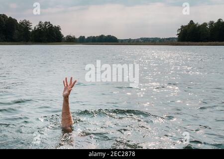 Eine Hand des ertrinkenden Mannes im Meer, der um Hilfe bittet Stockfoto