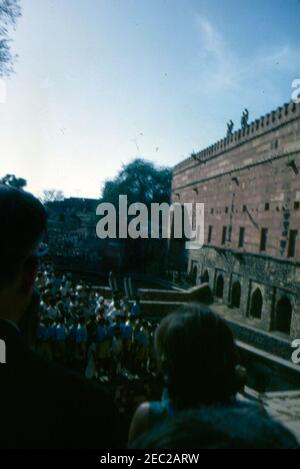 First Lady Jacqueline Kennedyu2019s (JBK) Reise nach Indien und Pakistan: Uttar Pradesh, Indien, Besuch in Fatehpur Sikri. First Lady Jacqueline Kennedy (im Vordergrund, zurück zur Kamera) beobachtet Taucher springen in einem Pool von Wasser von der Spitze des Victory Gate in der 16th-Jahrhundert-Mughal Stadt Fatehpur Sikri in Uttar Pradesh, Indien. Stockfoto