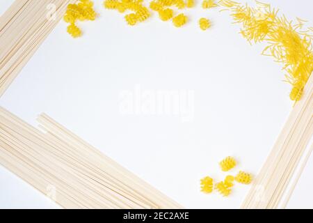 Auf einem weißen Hintergrund auf den Seiten sind verschiedene Pasta: Spaghetti, Vermicelli, Spiralen Stockfoto