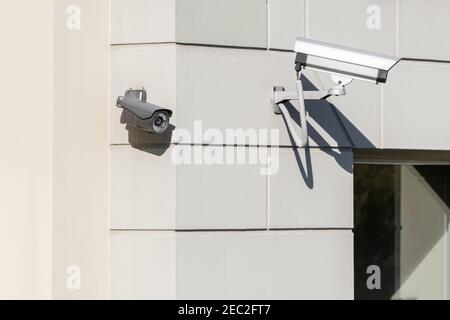 Moderne CCTV-Kameras an Gebäudewand in der Stadt installiert. Konzept der Überwachung und Überwachung. Stockfoto