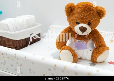 Pkture eines braunen Teddybären mit Windel auf dem Sitzen Im Babybett Stockfoto