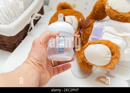 Pkture eines braunen Teddybären mit Windel auf dem Sitzen Im Babybett Stockfoto