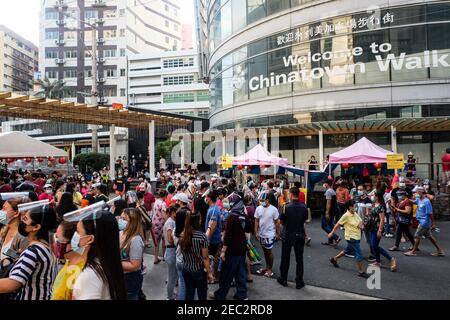 Ongpin St., Binondo, Manila, Philippinen. Februar 2021, 13th. Menschen mit Gesichtsmasken und Gesichtsschilden gehen in Ongpin, Binondo, während der Feier des chinesischen Neujahrs durch die mit chinesischen Laternen geschmückten Straßen. Binondo ist als das älteste chinatown der Welt bekannt, die meisten Feiern wie Drachen- und Löwentänze wurden aufgrund der Pandemie abgesagt. Kredit: Majority World CIC/Alamy Live Nachrichten Stockfoto