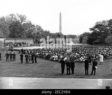 First Lady Jacqueline Kennedyu0027s (JBK) Musikprogramm für Jugendliche, 2:10pm. Ein Publikum, das auf dem South Lawn des Weißen Hauses versammelt ist, sieht Joseph Pival während der sechsten Ausgabe von First Lady Jacqueline Kennedyu2019s Musical Programs for Youth by Youth eine Aufführung des Central Kentucky Youth Symphony Orchestra dirigieren. Das Washington Monument und das Jefferson Memorial sind im Hintergrund zu sehen. Washington, D.C. Stockfoto