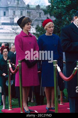 Ankunftszeremonie für Konrad Adenauer, Bundeskanzler der Bundesrepublik Deutschland, 10:45am Uhr. First Lady Jacqueline Kennedy nimmt an den Ankunftszeremonien zu Ehren des Bundeskanzlers der Bundesrepublik Deutschland, Dr. Konrad Adenauer, Teil. Libeth Werhahn, Tochter von Bundeskanzler Adenauer, steht rechts auf der Überprüfungsplattform; Virginia Rusk, Frau des US-Außenministers Dean Rusk, steht links unter der Plattform. South Lawn, White House, Washington, D.C. Stockfoto