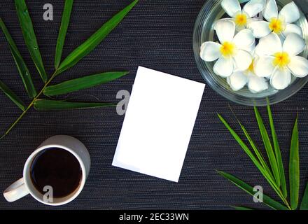 Bambusblatt auf rustikalem Holz. Asiatischer Zen-Hintergrund. Leeres Papier in Bambusblatt und Frangipani Blume. Plumeria Handbad. Tropisches flaches Lay. Spa-Schönheit Stockfoto