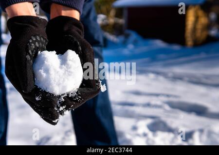 Im Winter das Herz aus dem Schnee in den Händen halten Tag Stockfoto