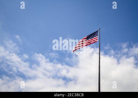 Amerikanische Flagge winkt in den wolkigen blauen Himmel auf einem Sonniger Tag Stockfoto