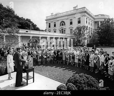 Besuch des Nationalrates der Liga der Frauen Wähler, 9:55am. Präsident John F. Kennedy spricht im Rosengarten des Weißen Hauses, Washington, D.C., an eine Gruppe von Vertretern des Nationalrats der Liga der Wählerinnen (LWV).Neben Präsident Kennedy steht Präsidentin des LWV, Ruth S. Phillips; alle anderen sind nicht identifiziert. Stockfoto