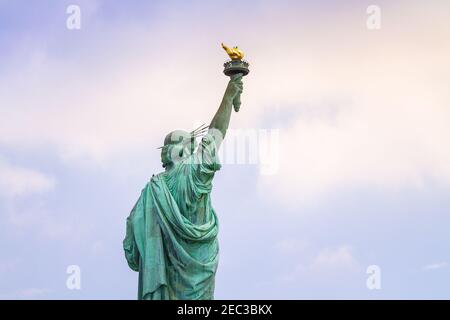 Nahaufnahme der Freiheitsstatue in New York von hinten gesehen mit wolkenblauem Himmel Stockfoto