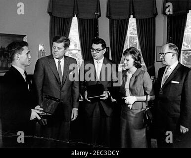 Besuch der Gewinner der William Randolph Hearst Awards, Nicholas Gage und Judy Harrington, 5:10pm Uhr. Präsident John F. Kennedy besucht mit den Empfängern der dritten jährlichen William Randolph Hearst Foundation Journalism Awards. Von links nach rechts: Preisträger Nicholas Gage von der Boston University; Präsident Kennedy; Direktor der School of Journalism an der University of Nebraska, Dr. William E. Hall; Preisträgerin Judy Harrington von der University of Nebraska; Vorsitzender des Board of Regents der University of Nebraska, Dr. Ben Greenberg. Oval Office, White House, Washington, D.C. [Anmerkungen: CRAC Stockfoto
