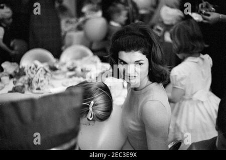 Geburtstagsfeier für Caroline Kennedy und John F. Kennedy, Jr.. First Lady Jacqueline Kennedy sitzt an einem Tisch mit ihrer Tochter Caroline Kennedy (Kopf gebeugt), während einer gemeinsamen Geburtstagsfeier für Caroline und John F. Kennedy, Jr. Presidentu2019s Dining Room (Residenz), White House, Washington, D.C. Stockfoto