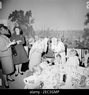 Geburtstagsfeier für Caroline Kennedy und John F. Kennedy, Jr.. John F. Kennedy, Jr. (sitzt in der Mitte), isst an einem Tisch im Presidentu2019s Dining Room (Residenz) des Weißen Hauses, Washington, D.C., während einer gemeinsamen Geburtstagsfeier für ihn und seine Schwester, Caroline Kennedy. Kindermädchen für die Kennedy-Kinder, Maud Shaw, steht hinter John, Jr.; Eunice Kennedy Shriver spricht mit einer unbekannten Frau links. Stockfoto