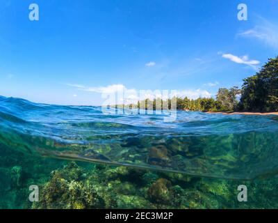 Doppelte Landschaft mit Meer und Himmel. Meer Panorama Split Foto. Blick auf die Unterwasserwelt mit tropischer Küste der Insel. Über und unter der Wasserlinie. Schnorcheln Stockfoto