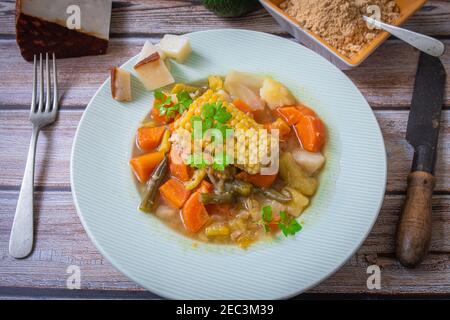 Gemüseeintopf und sehr gesunder Maisgofio mit Avocado Stockfoto