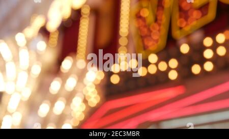 Defokussierte alte angefaste elektrische Lampen leuchten in der Nacht. Abstrakte Nahaufnahme von verschwommener Retro-Casino-Dekoration schimmernd, Las Vegas USA. Beleuchtetes vi Stockfoto