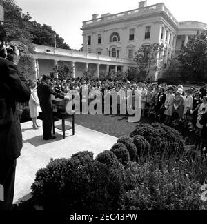 Besuch des Nationalrates der Liga der Frauen Wähler, 9:55am. Präsident John F. Kennedy spricht im Rosengarten des Weißen Hauses, Washington, D.C., an eine Gruppe von Vertretern des Nationalrats der Liga der Wählerinnen (LWV).Neben Präsident Kennedy steht Präsidentin des LWV, Ruth S. Phillips; alle anderen sind nicht identifiziert. Stockfoto