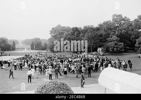 First Lady Jacqueline Kennedyu0027s (JBK) Musikprogramm für Jugendliche, 10:35am. Präsident John F. Kennedy (versteckt im Hintergrund) spaziert durch eine Menge von Teilnehmern, nachdem er bei der vierten Reihe von musikalischen Jugendprogrammen der First Lady Jacqueline Kennedyu0027s Rede gehalten hat. South Lawn, White House, Washington, D.C. Stockfoto