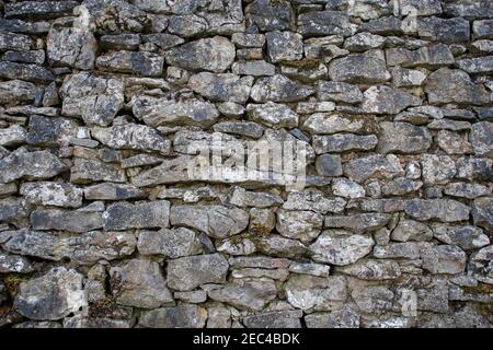 Eine alte graue Steinwand mit rauer Textur Stockfoto